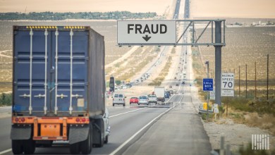 truck on highway with "fraud" sign
