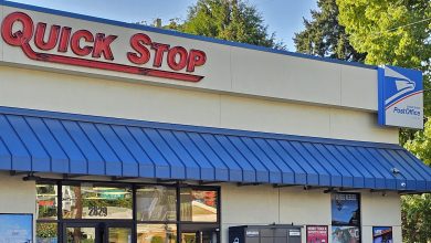 A Quick Stop convenience store entrance with a USPS sign on the front facade.