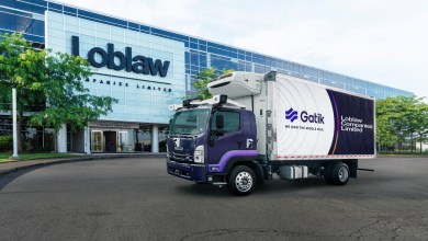 A Gatik autonomous truck with a refrigeration unit parked in front of the Loblaw Companies Limited building, featuring branding for their middle-mile logistics partnership.