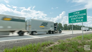 An ABF Freight tractor pulling two LTL trailers on a highway