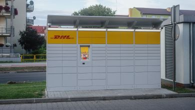 Photo of a parcel locker unit with yellow DHL brand on it.