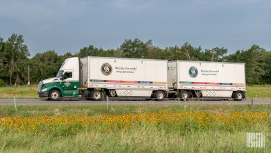 a side view of an Old Dominion tractor pulling two OD pup trailers on a side road