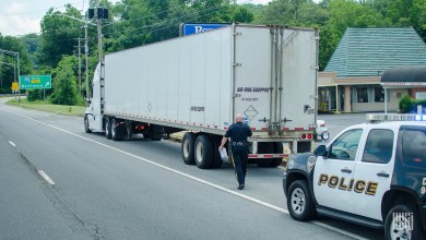 Law enforcement pulling over a truck driver.