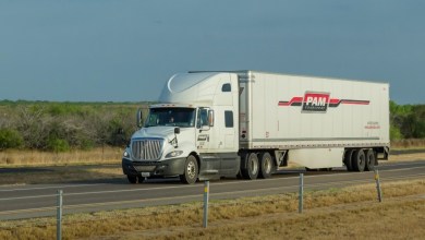 a white Pam tractor pulling a white Pam dryvan trailer