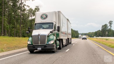 An Old Dominion tractor pulling two pup trailers on a highway