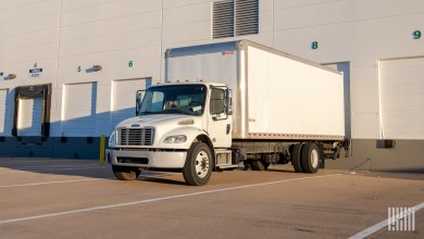 A white truck with a lift gate at a dock door