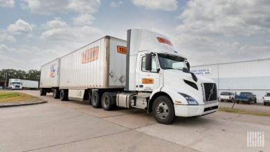 a Yellow daycab pulling Yellow and YRC trailers at a facility