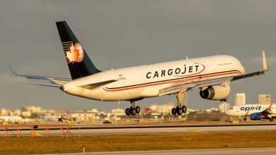 A blue-tailed Cargojet with Canadian maple leaf logo lands on a runway.
