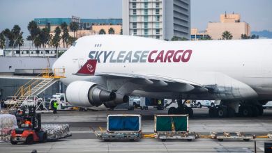Close up view from side rear of a Sky Lease Cargo 747 jumbo jet at an airport with cargo on the tarmac.