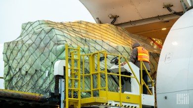 an air cargo container being loaded on a plane