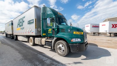 a green ABF daycab pulling two pup trailers into a warehouse