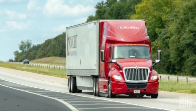 A red Knight Transportation tractor pulling a Knight trailer on a highway