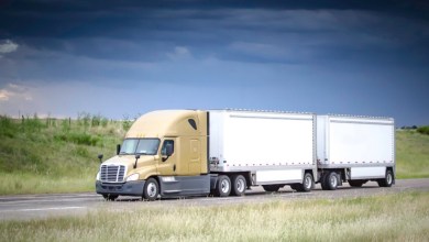 a gold sleeper cab pulling two pup trailers