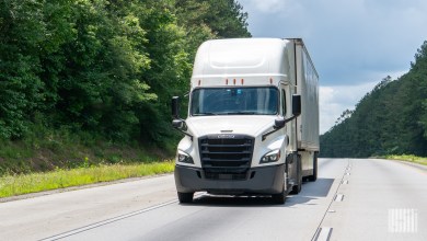a white tractor pulling a white trailer