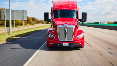 Red Kenworth T680 semi-truck powered by Kodiak AI autonomous driving technology driving on a highway, highlighting advancements in driverless trucking and the Kodiak AI Bosch partnership for scaled manufacturing.