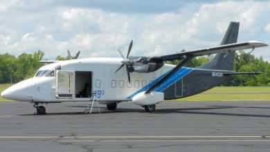 A funky Shorts turboprop plane on an airport ramp with side door open on a clear day. Side view.