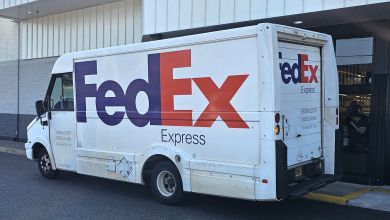 Side view of a FedEx van parked next to a store.