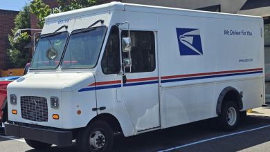 Close up front-side view of a USPS delivery truck.
