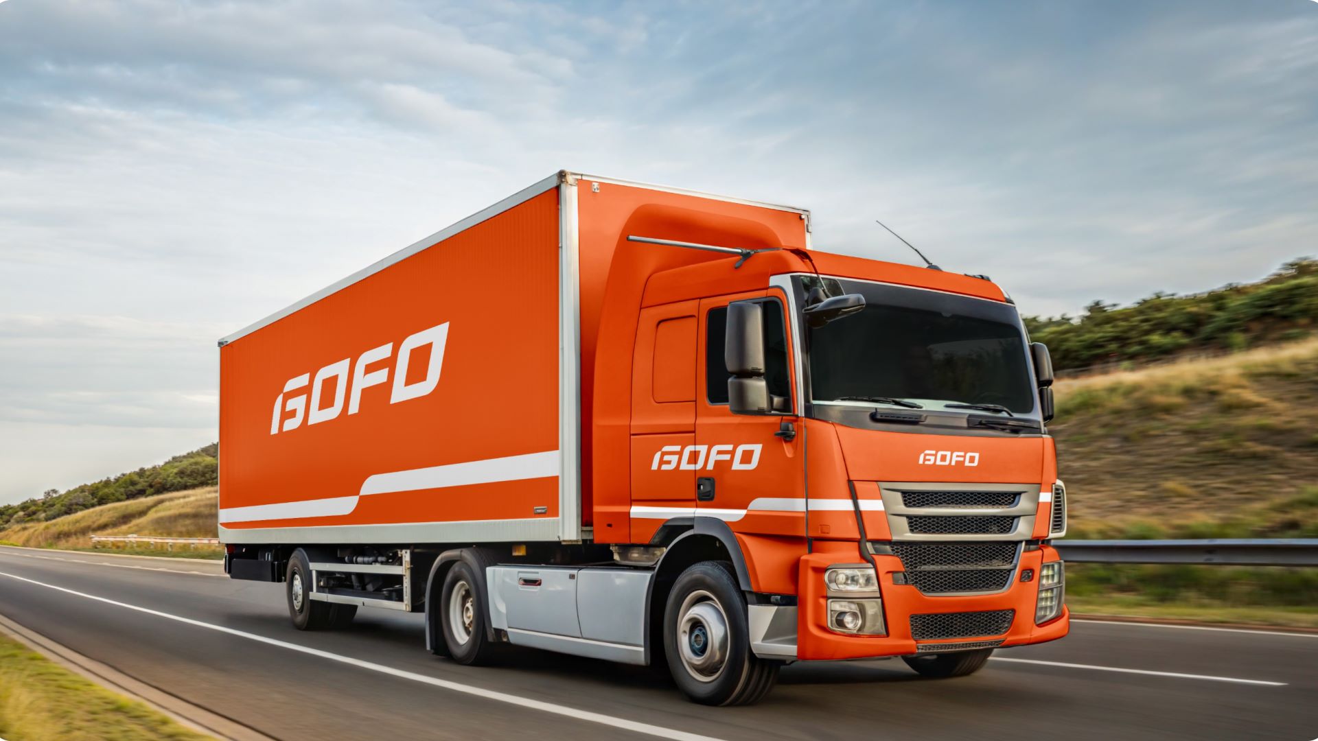 An orange Gofo truck heads down the highway.