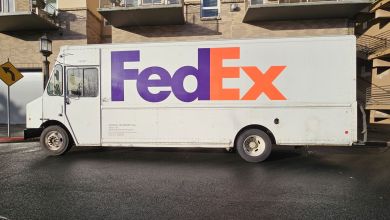 Side view of a FedEx van parked on a street.