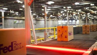 FedEx parcels move along a conveyor belt in a warehouse.