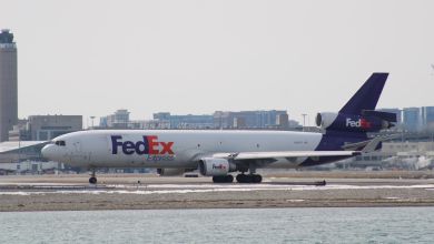 Side view of a purple-tailed FedEx MD-11 freighter on the taxiway.