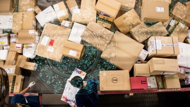 Overhead view of parcels spread out on a table or conveyor belt in a logistics facility.