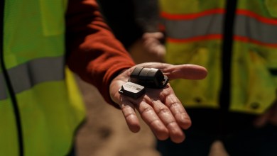 Samsara Asset Tag and Asset Tag XS Bluetooth tracking devices held in a construction worker’s hand