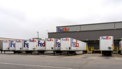 FedEx Express trailers parked along a FedEx warehouse.