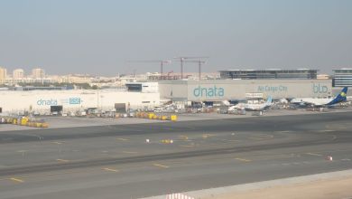 A dnata air cargo terminal at the Dubai airport with planes parked in front.
