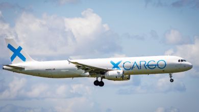 A GlobalX Cargo jet seen on approach to an airport with clouds in background.