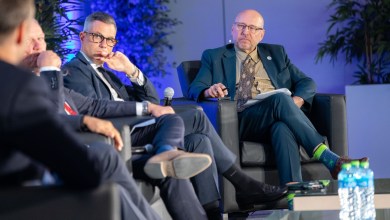 Panelists sitting on a stage at an industry conference.