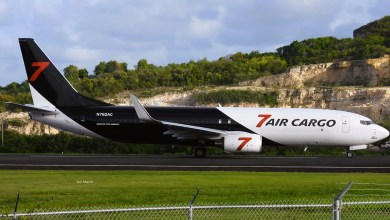 A black-white 7Air Cargo jet seen from the side after landing on a Caribbean island runway.