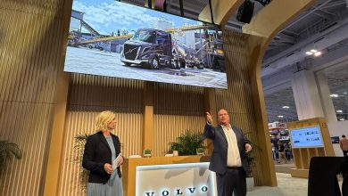 Volvo Trucks executives present major announcements at the TMC 2026 annual meeting in Nashville, with a large screen displaying the new VNL truck behind them.
