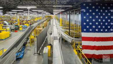 Large modern U.S. warehouse distribution center interior with long automated conveyor belt systems and a prominent American flag