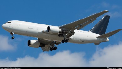 A big jet with no brand markings comes in for a landing as seen from below.