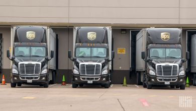 Three UPS tractor-trailers backed in at a warehouse receiving dock.