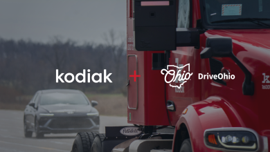 Red Kodiak autonomous truck on the highway with prominent Kodiak + DriveOhio partnership branding