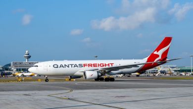 A red-tailed Qantas Freight cargo jet is seen on the tarmac on a clear day.