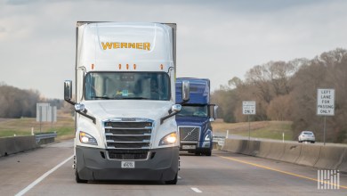 A white Werner tractor pulling a trailer on a highway