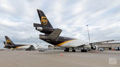Rear view at airport terminal of a brown-tailed UPS MD-11 plane with tail-mounted engine.
