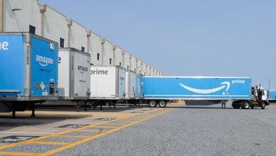 Blue Amazon Prime trailers at an Amazon warehouse.