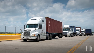 trucks pulling ocean containers on chassis near a port