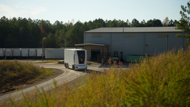 A white, cabless Einride vehicle driving outside a large warehouse, demonstrating the expansion of autonomous trucking in Ohio.