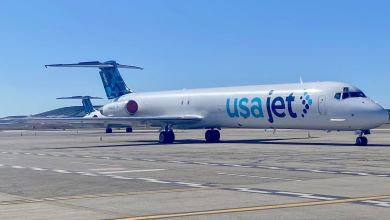 A McDonnell Douglas MD-88 tri-jet with blue accents sits on a tarmac.