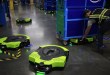 Green-and-black robotic saucers are moving carts of packages in Amazon fulfillment centers.