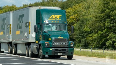a green ABF tractor pulling two ABF pup trailers