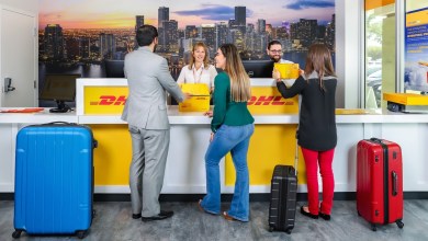 A family drops their travel bags at a DHL Express counter for storage.