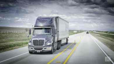 Knight-Swift semi-truck driving on a rural multi-lane highway under dramatic cloudy skies, central to the Iron Insurance Disaster investigation.