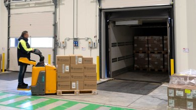 A warehouse worker used a pallet cart to move boxes into a truck trailer.